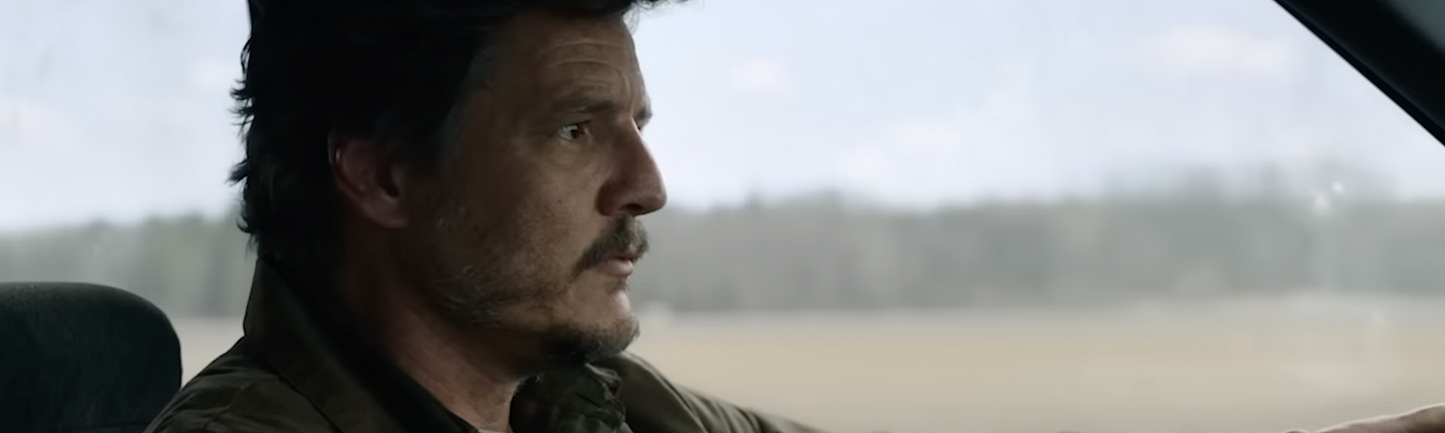 Pedro Pascal, playing Joel in HBO’s The Last of Us, is driving a car.