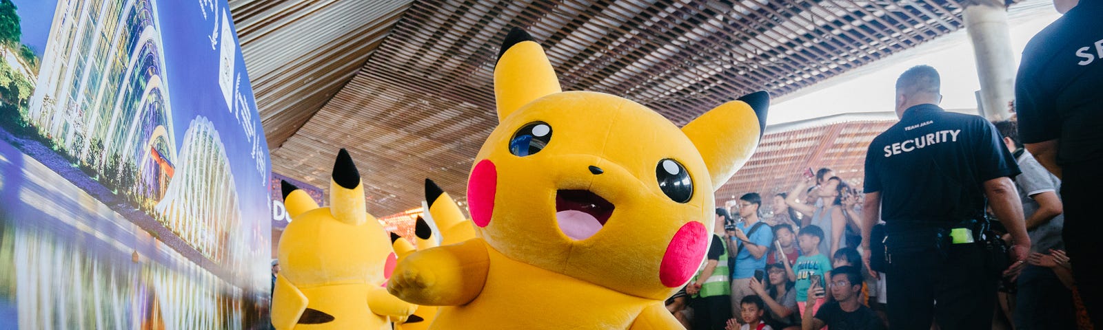 Someone in a Pikachu suit is smiling at the camera;