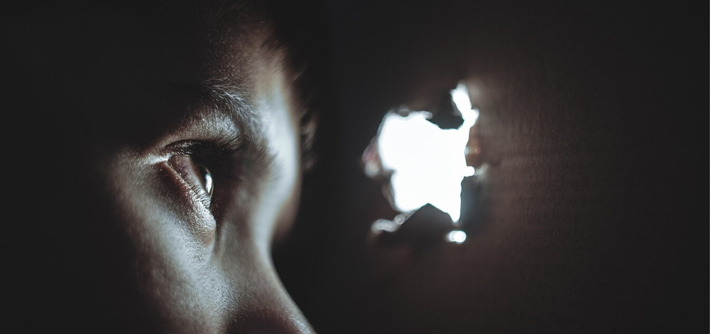 Boy looking out through hole in box-”The Madness Box” by “Arthur G. Hernandez”