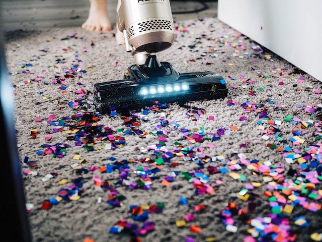 Vacuuming party confetti in bare feet