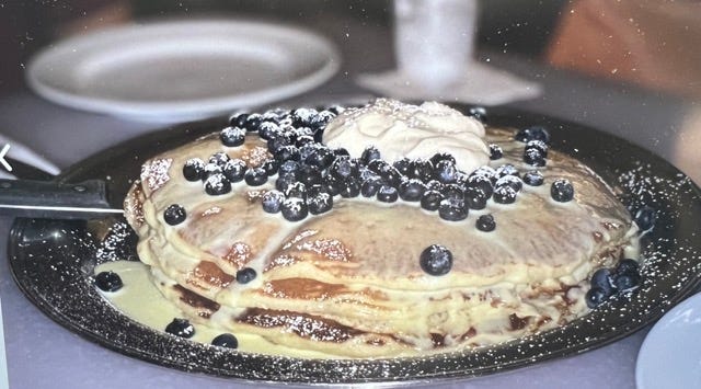 A full view of five pounds of pancakes, including blueberries, butter, and whipped cream, at the MAC 24/7 in Oahu, Hawaii.