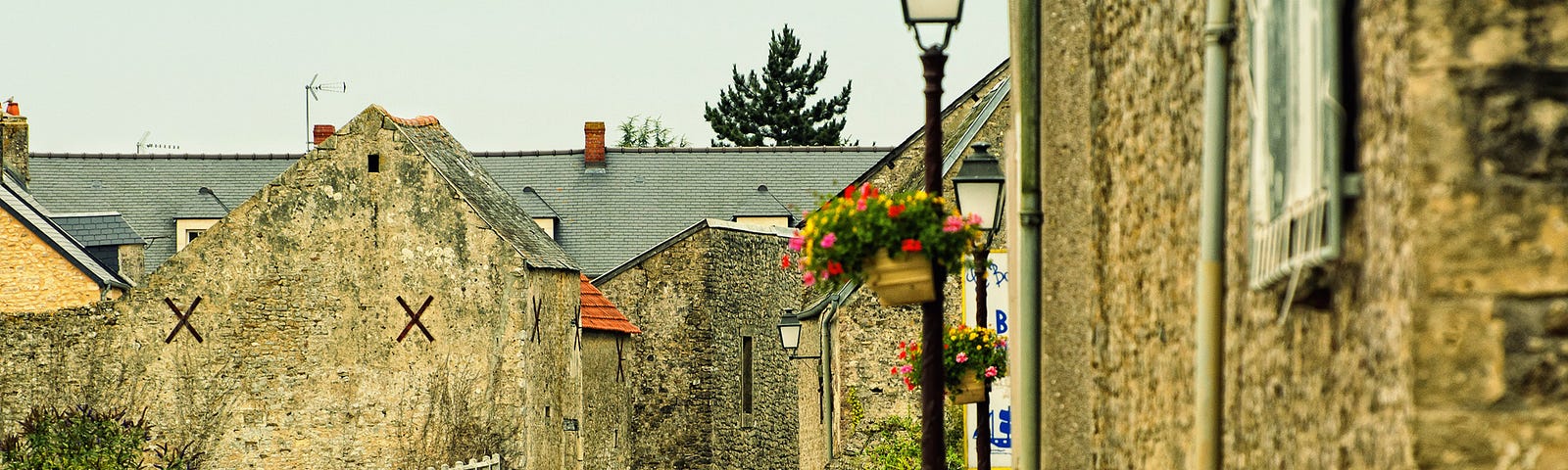 Grey stone buildings on French village street.