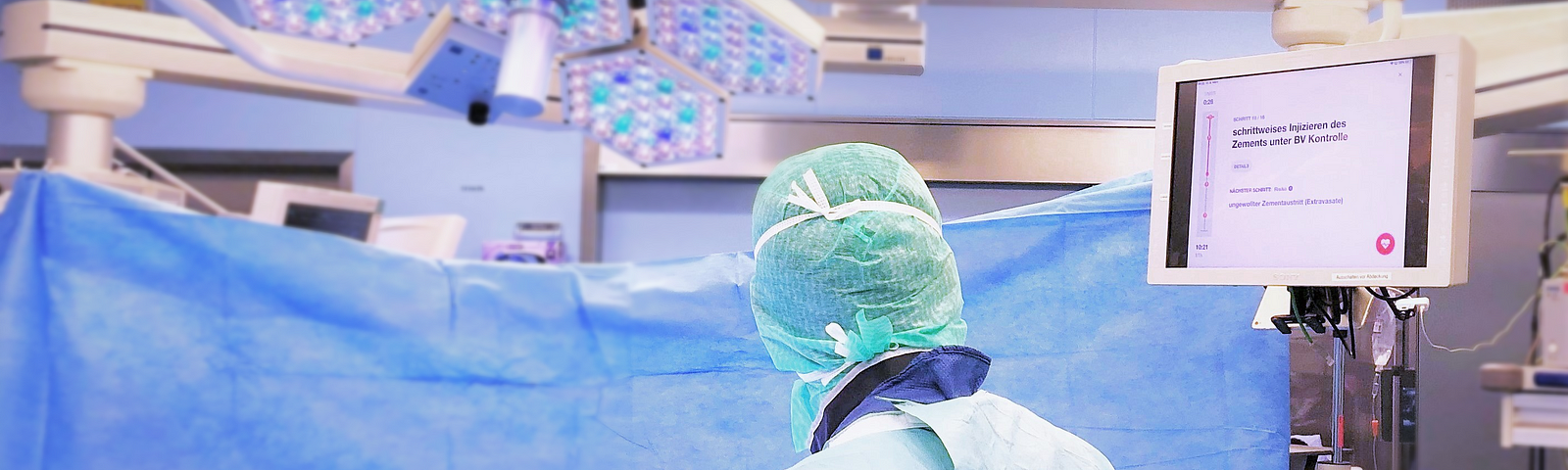 A surgeon looking at the Nodus Medical application on a screen in an operating room while performing a surgery.