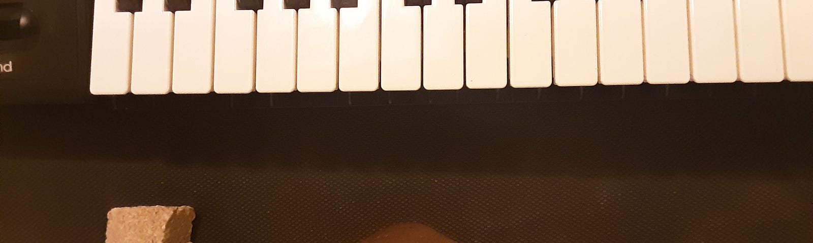 A piano’s keys next to a few hand-sized rocks of various shapes.