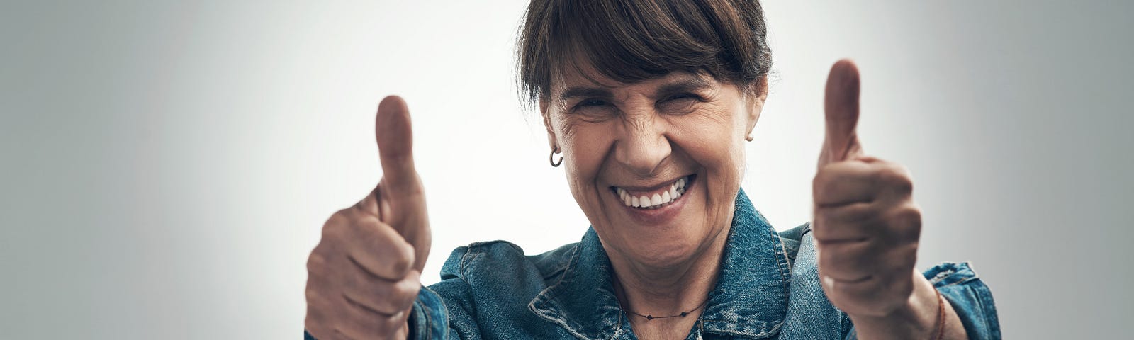 enthusiastic woman in her 50s giving two thumbs up