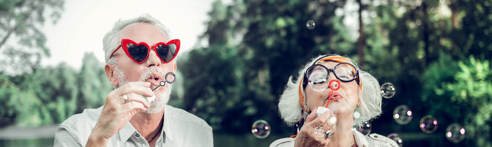 Baby Boomers man and woman couple blowing bubbles. G. K. Hunter