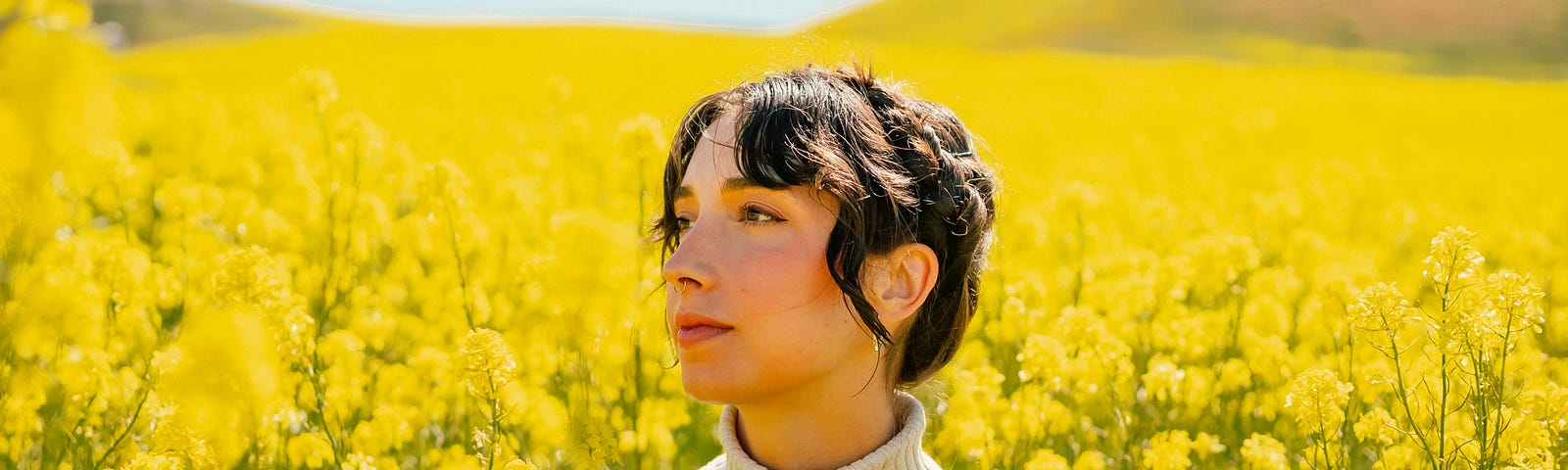 A woman sitting in a field of yellow flowers