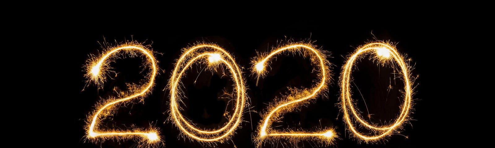 An image of bright gold fireworks spelling out “2020” against a black background.