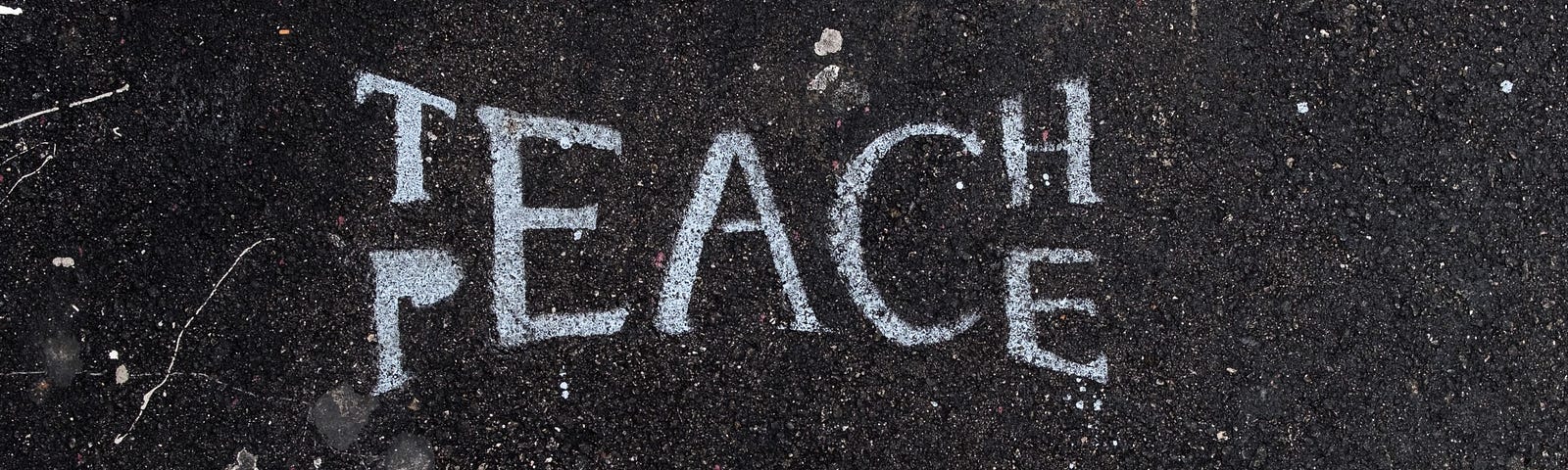 The words “Teach Peace” painted onto the asphalt in Los Angeles, CA