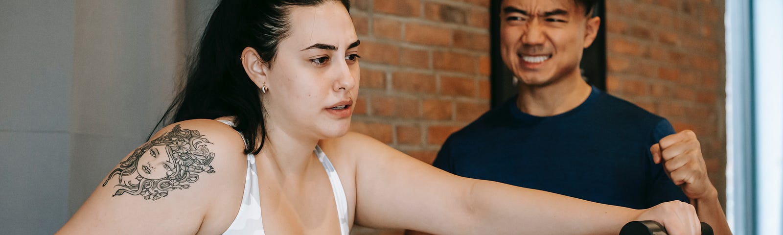 Overweight woman with a shoulder tattoo exercising