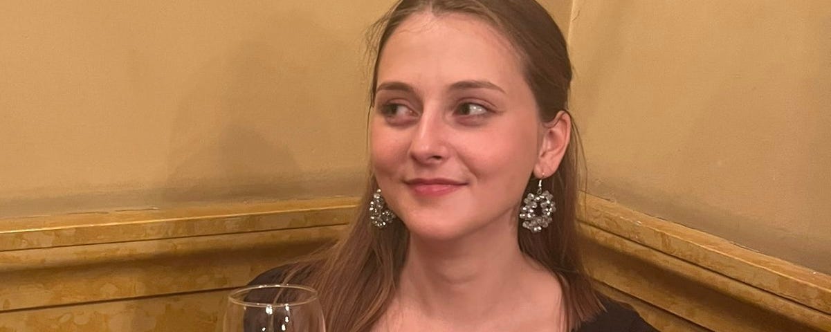 Picture of the writer drinking free wine at a function, taken by her best friend