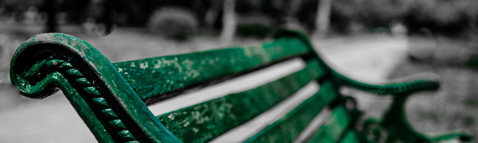 A green metal bench with peeling paint