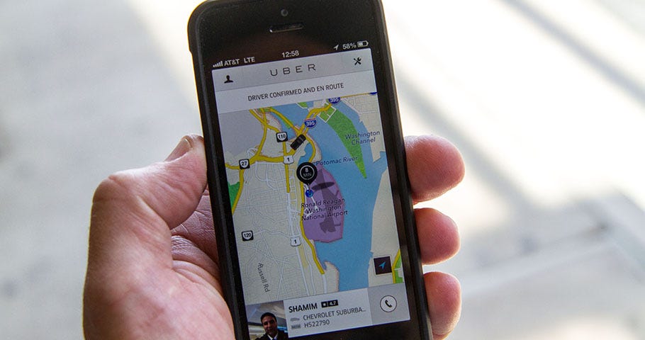 IMAGE: A hand holding a smartphone with the Uber map screen