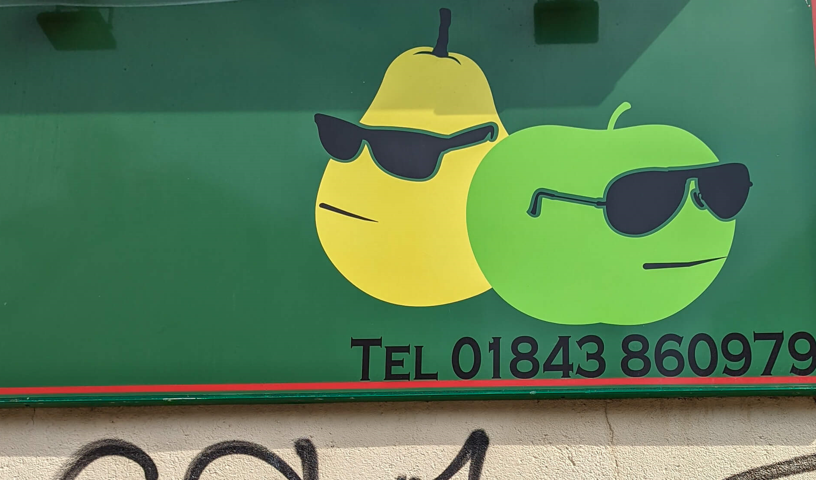 Mural of pear and apple wearing sunglasses above graffiti