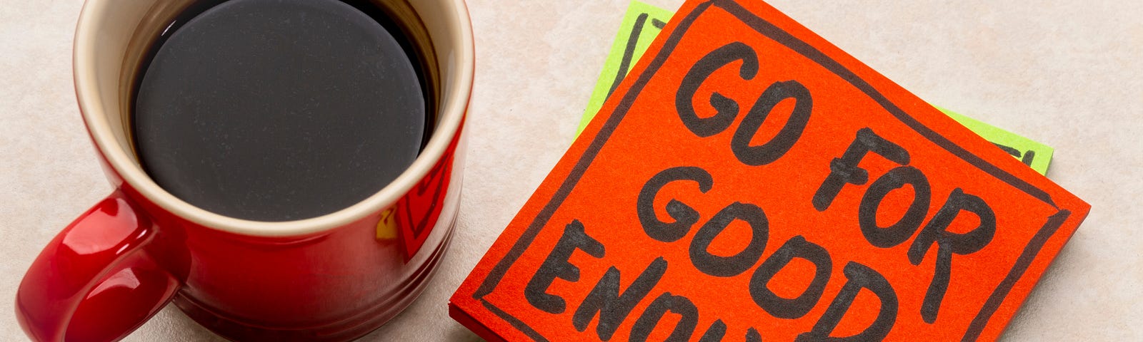Coffee cup with note saying “Go For Good Enough”.
