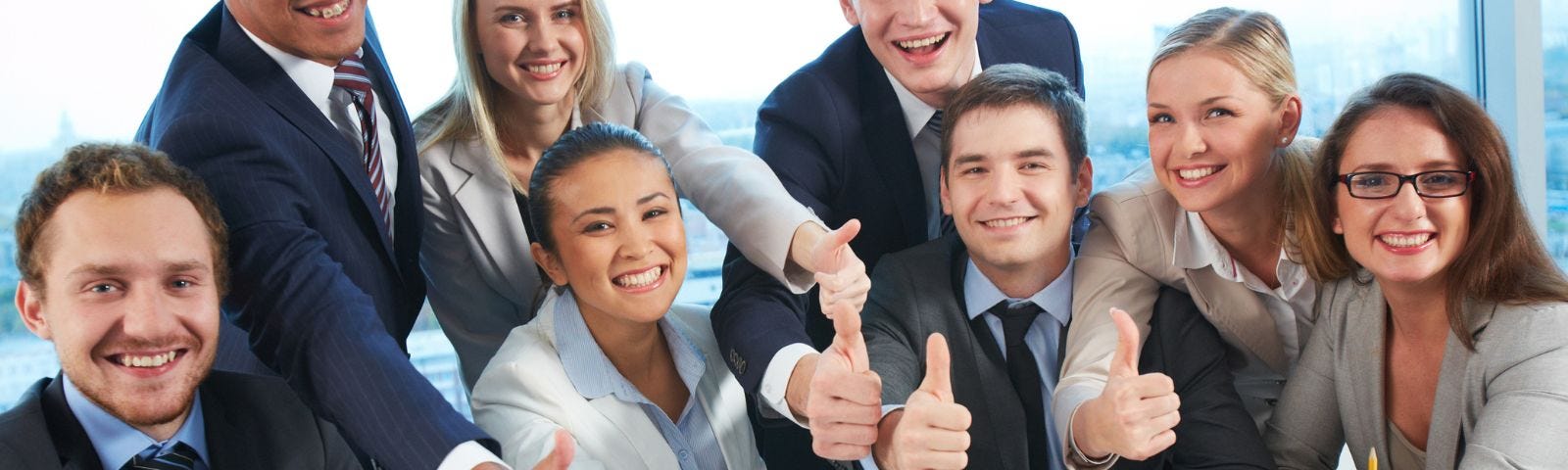 group of people in the office all with their thumbs up to represent toxic positivity
