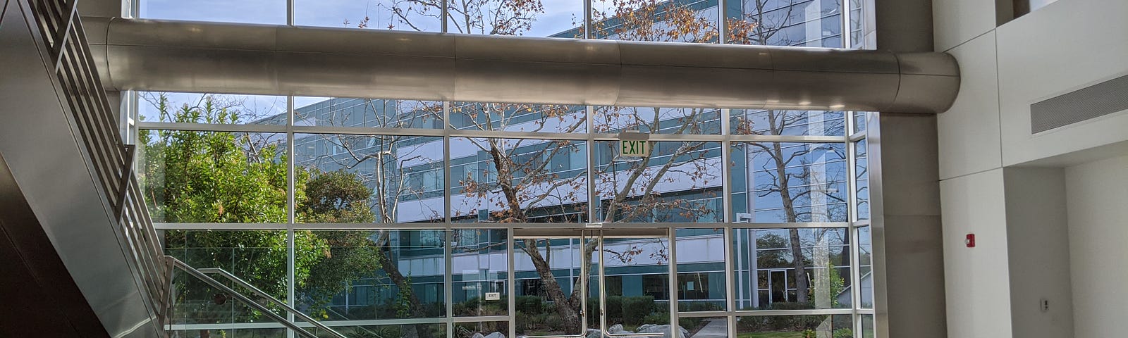 The building lobby at the Google San Diego office. A panel of glass windows overlooks the exterior of the corporate park.