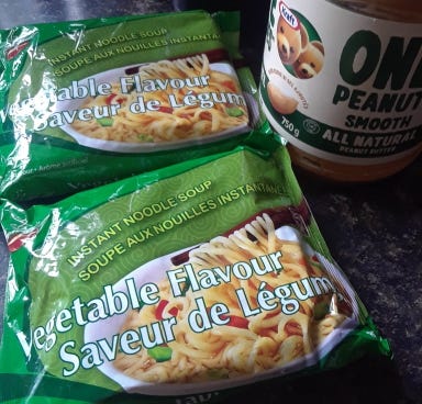 Two vegetable flavored noodle packs with some peanut butter.