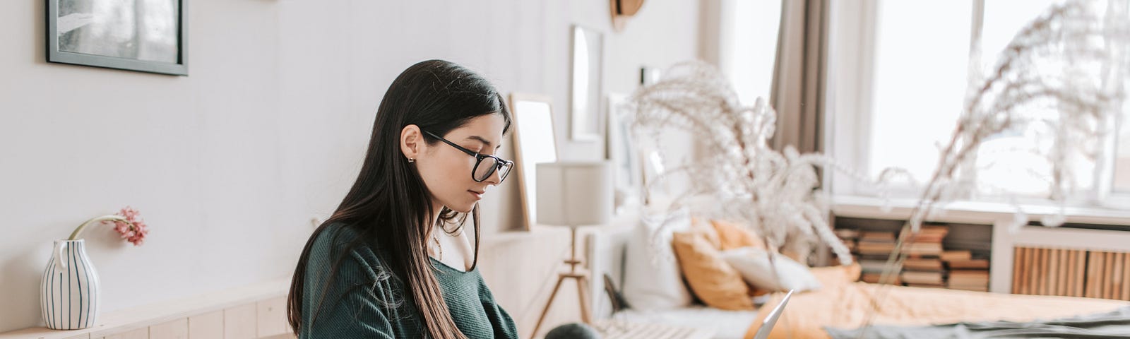 A young woman writing on her laptop