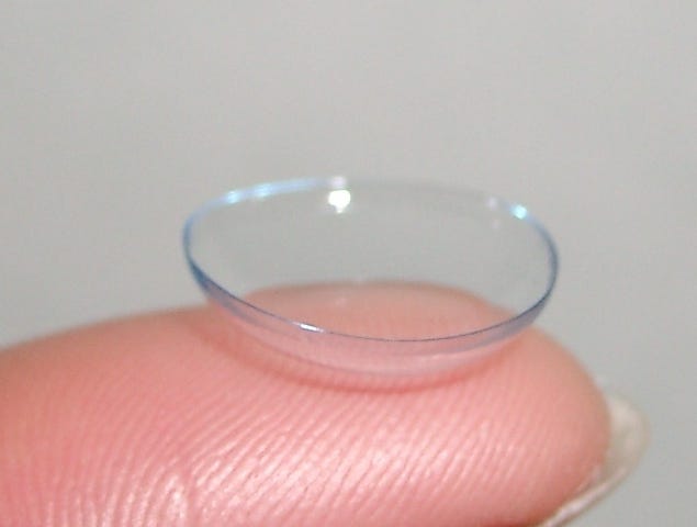 IMAGE: A finger holding a contact lens