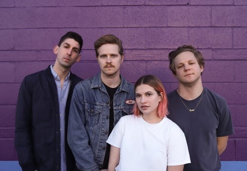 Tigers Jaw in front of a purple brick building.