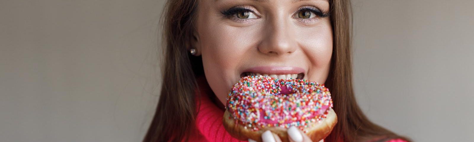 Young happy woman with donut smiling.