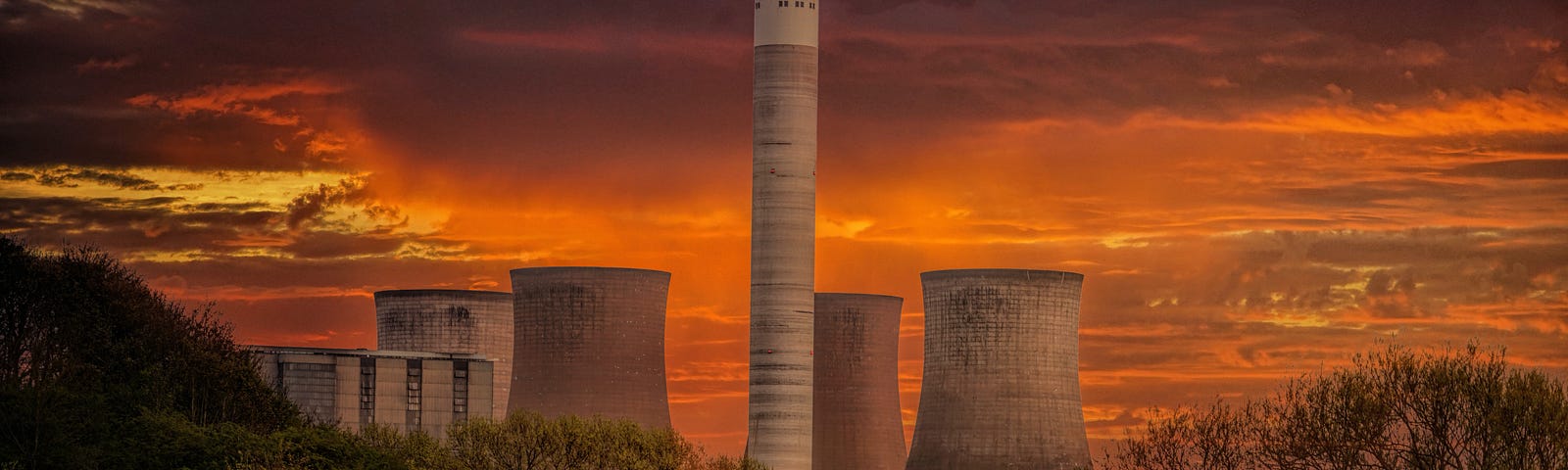 Nuclear Power Plant Silo under the range-lined clouds during sunset