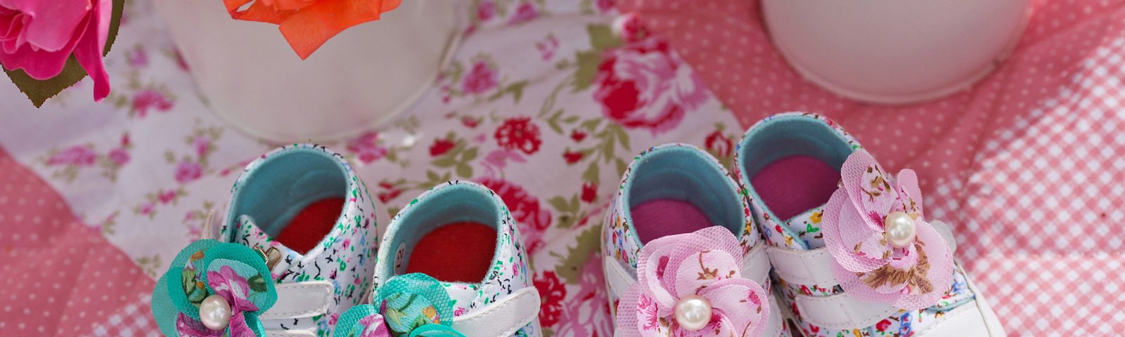 Flowers and Two Sets of Baby Shoes on a Quilt
