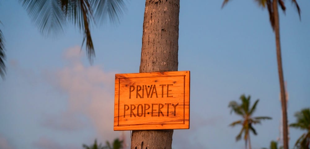 Picture of a  tree trunk with a sign saying “private property”