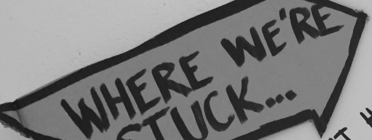 Signpost with words “where we’re stuck” on it