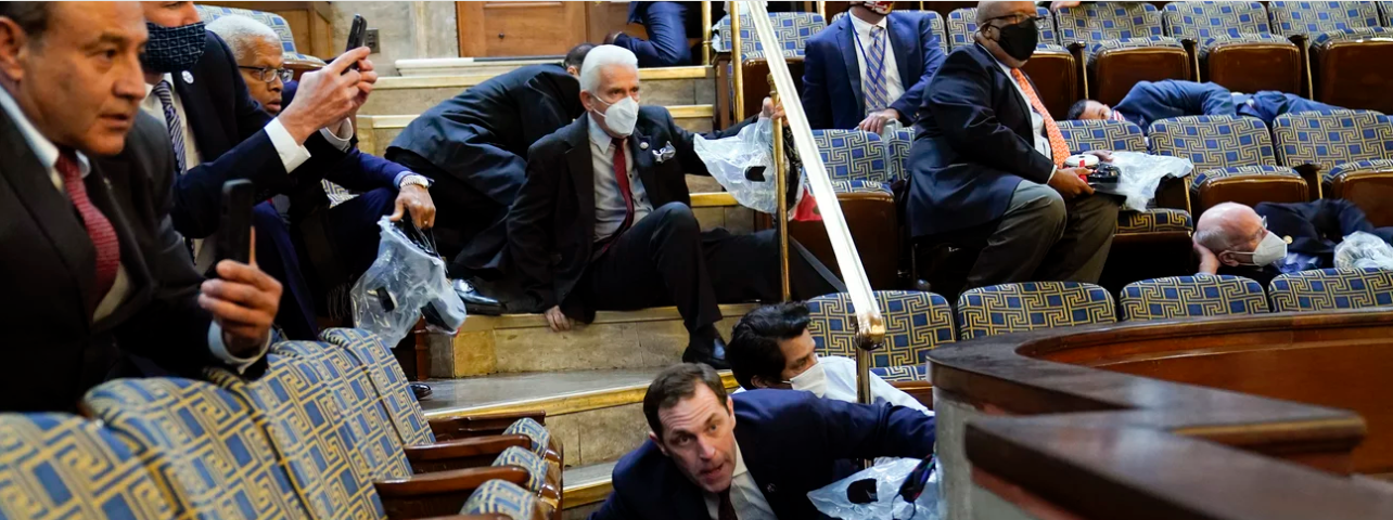 Photo in US Chamber. Representatives, staffers and observers shelter in place in the House gallery as rioters try to break into the chamber January 6, 2021
