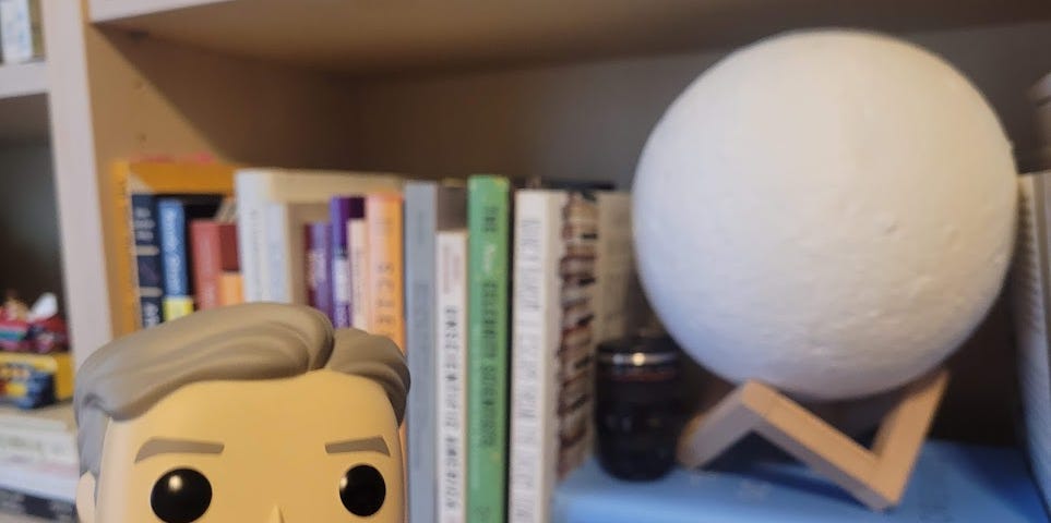 Funko Pop Bill Nye in front of a shelf of books