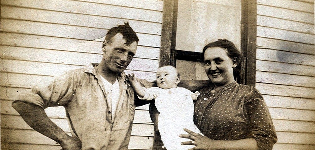 Sepia depression era image of a dirty man and his wife holding a baby