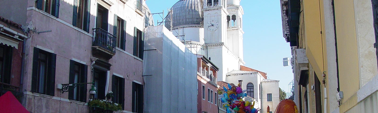 A narrow corridor behind the Basilica Santa Maria della Salute in Venice is crowded elbow to elbow with tourists.