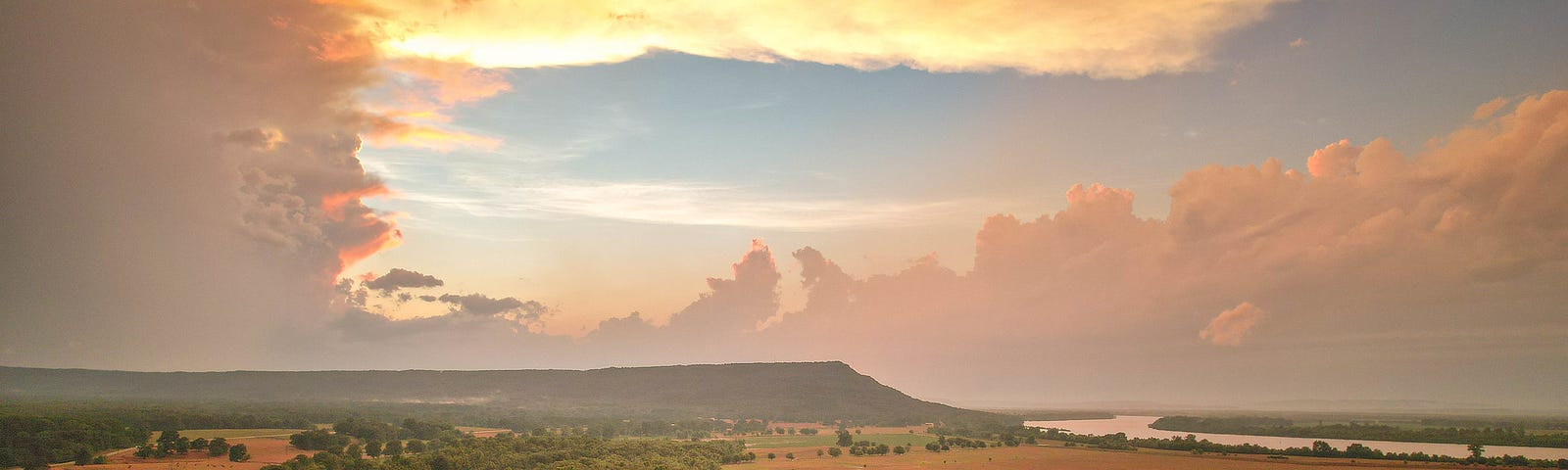 Petit Jean Mountaing and the Arkansas River valley under dramatic clouds and sunset after a summer storm.