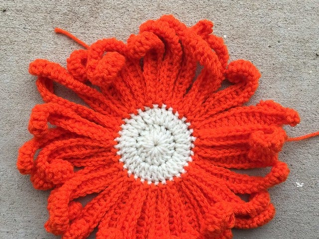 A bright orange crochet flower for a Day of the Dead crochet yarn bomb