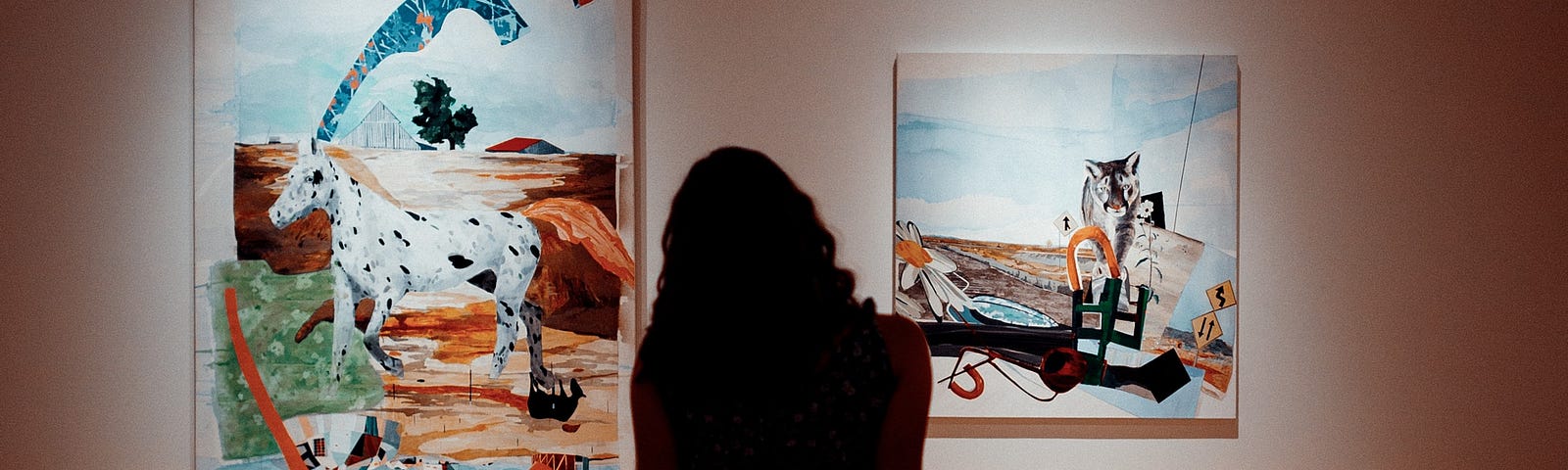 A woman is sitting alone in an art gallery, looking at two paintings on a wall.