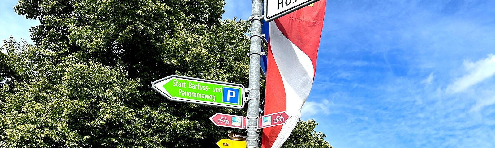 A typical sign post with signs for cars, bicyclists, hikers, and walkers, at a village intersection, eastern Switzerland.