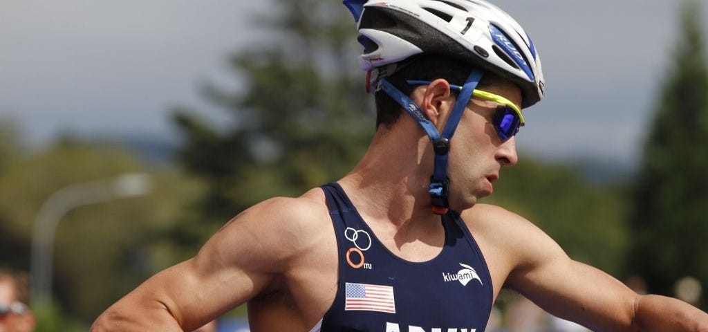 Nick Vandam shown in a biking helmet and apparel, competing in the 2012 Military Triathlon World Championship.