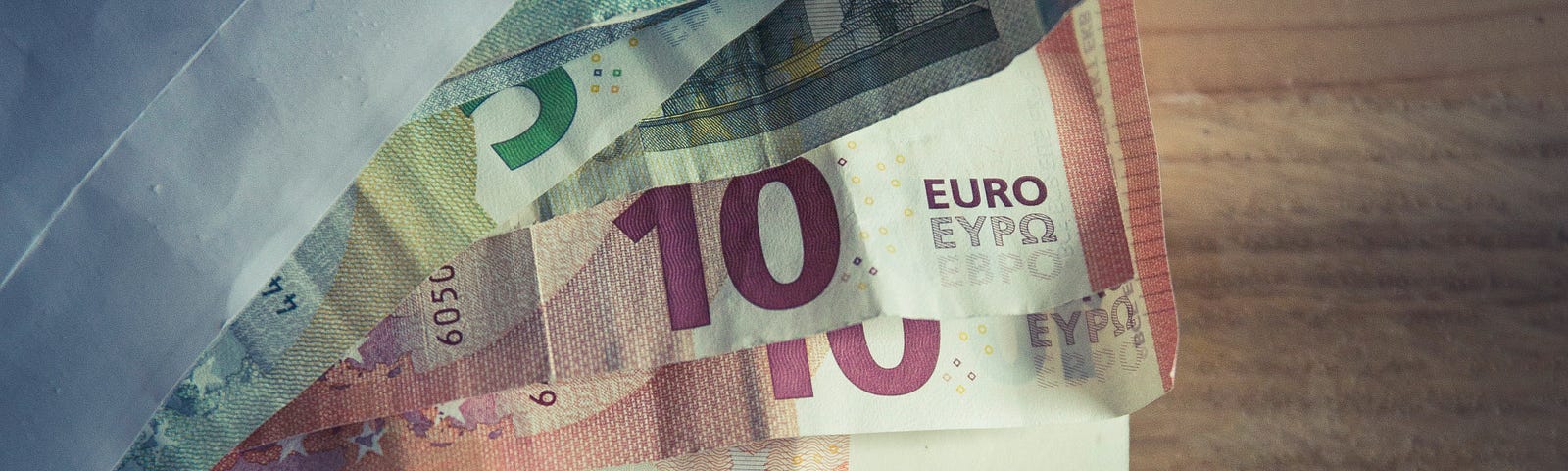 A picture of an envelope with euro bills of various denominations sticking out of it