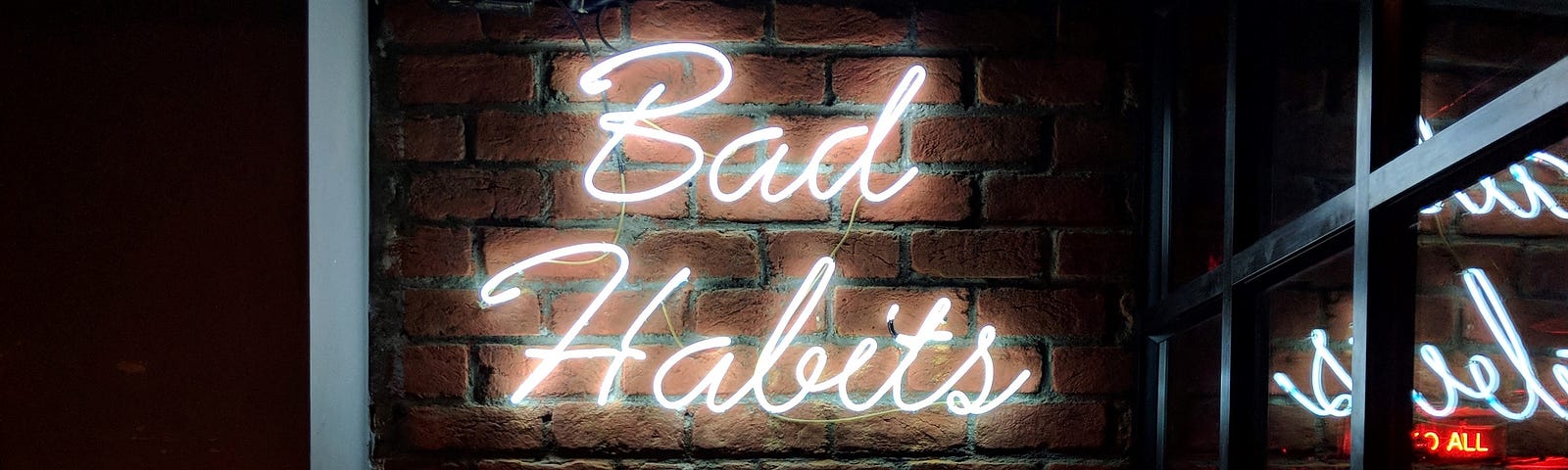 neon sign that says bad habits