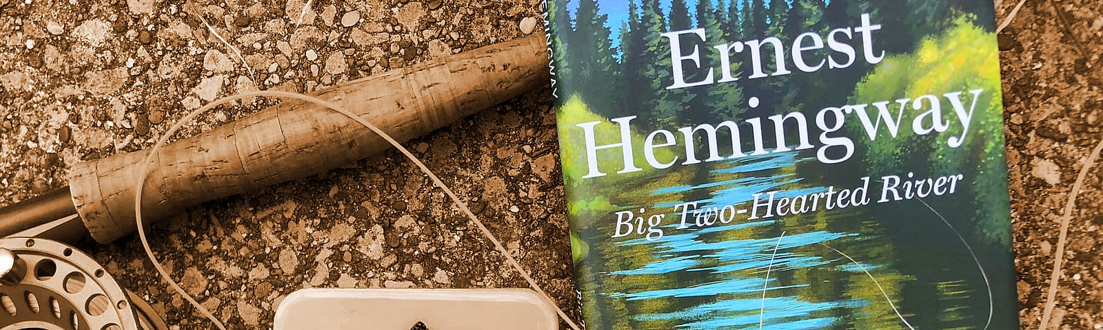 Ernest Hemingway book shown with fly rod and a small fly box.