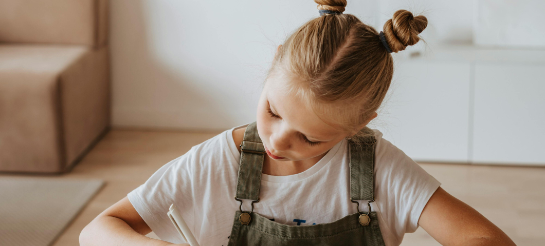 little girl writing in a notebook