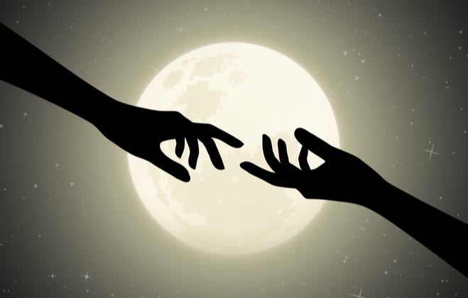 Two hands silhouetted by the moon