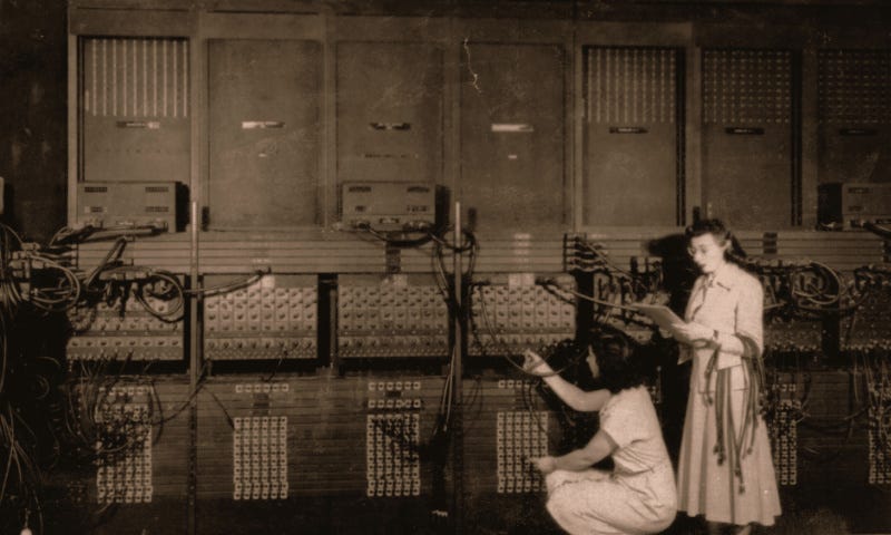 Two women programming the first programmable computer.