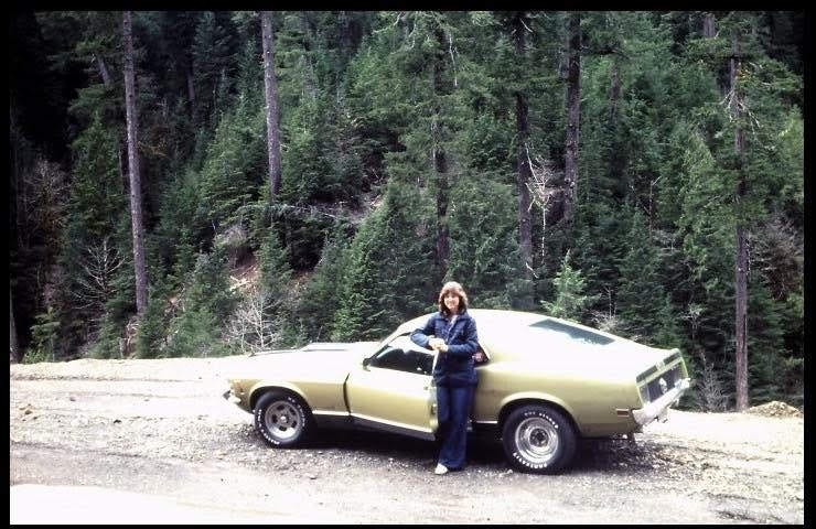 A very lovely young woman standing next to a Mach 1 Mustang back in 1976.