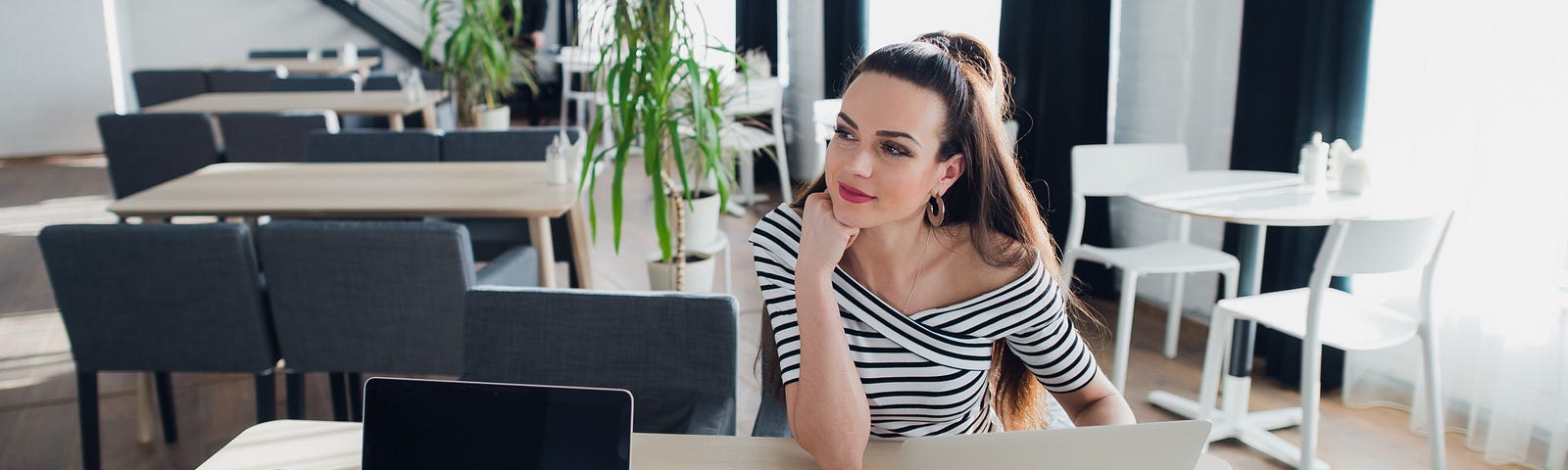 young attractive woman is sitting at the table planning to form a company