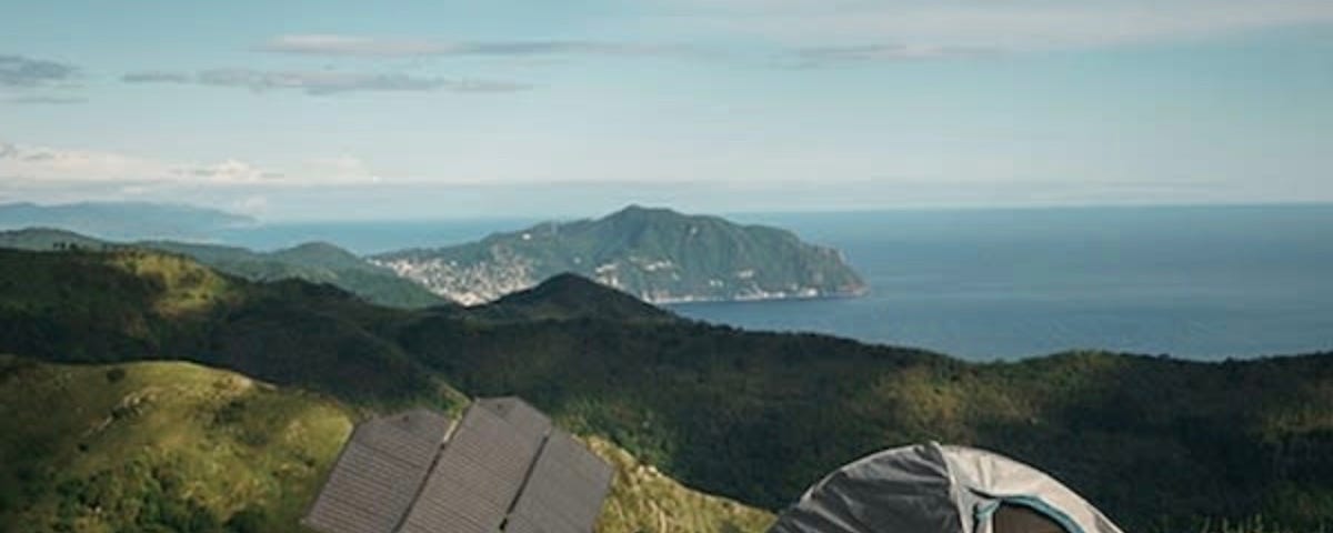 A view of the Levante folding solar panels with a nearby tent harnessing the power of the sun.