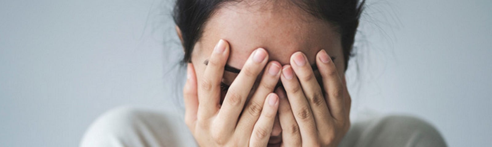 Photo of women with hands covering face with guilt.