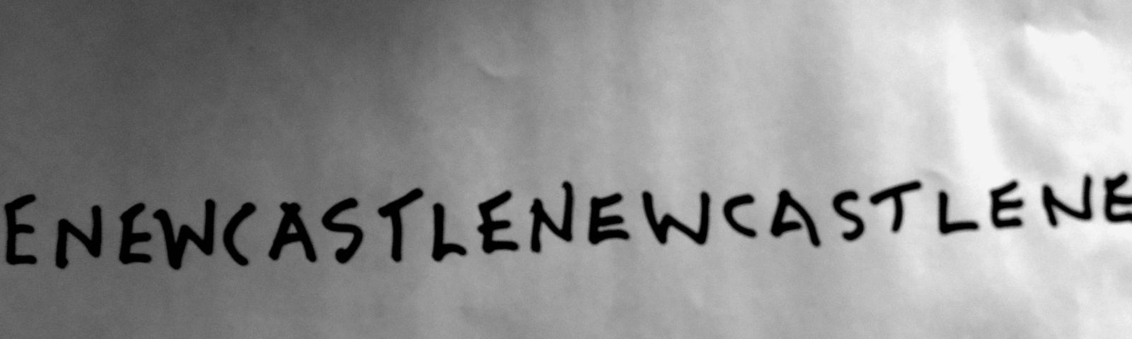 A blank sheet with the word Newcastle written across it in black felt pen, repeatedly with no spaces between words.